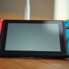 A Nintendo Switch on a kitchen table next to a Wi-Fi router, for changing DNS to join a Minecraft server
